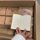 Caja con 70 cuadernos tapa de corcho